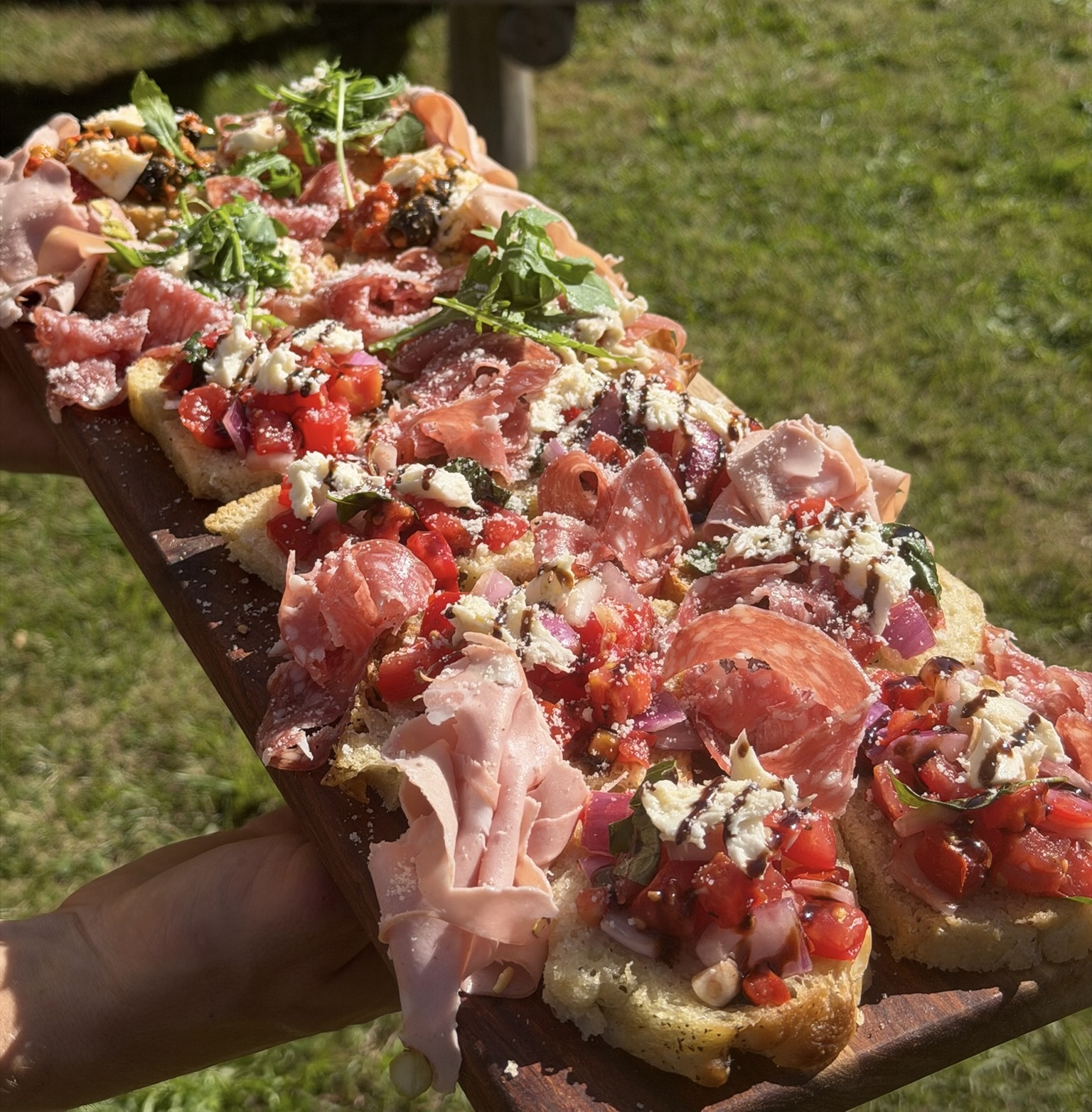 Houten plank met bruschetta, salami en mortadella