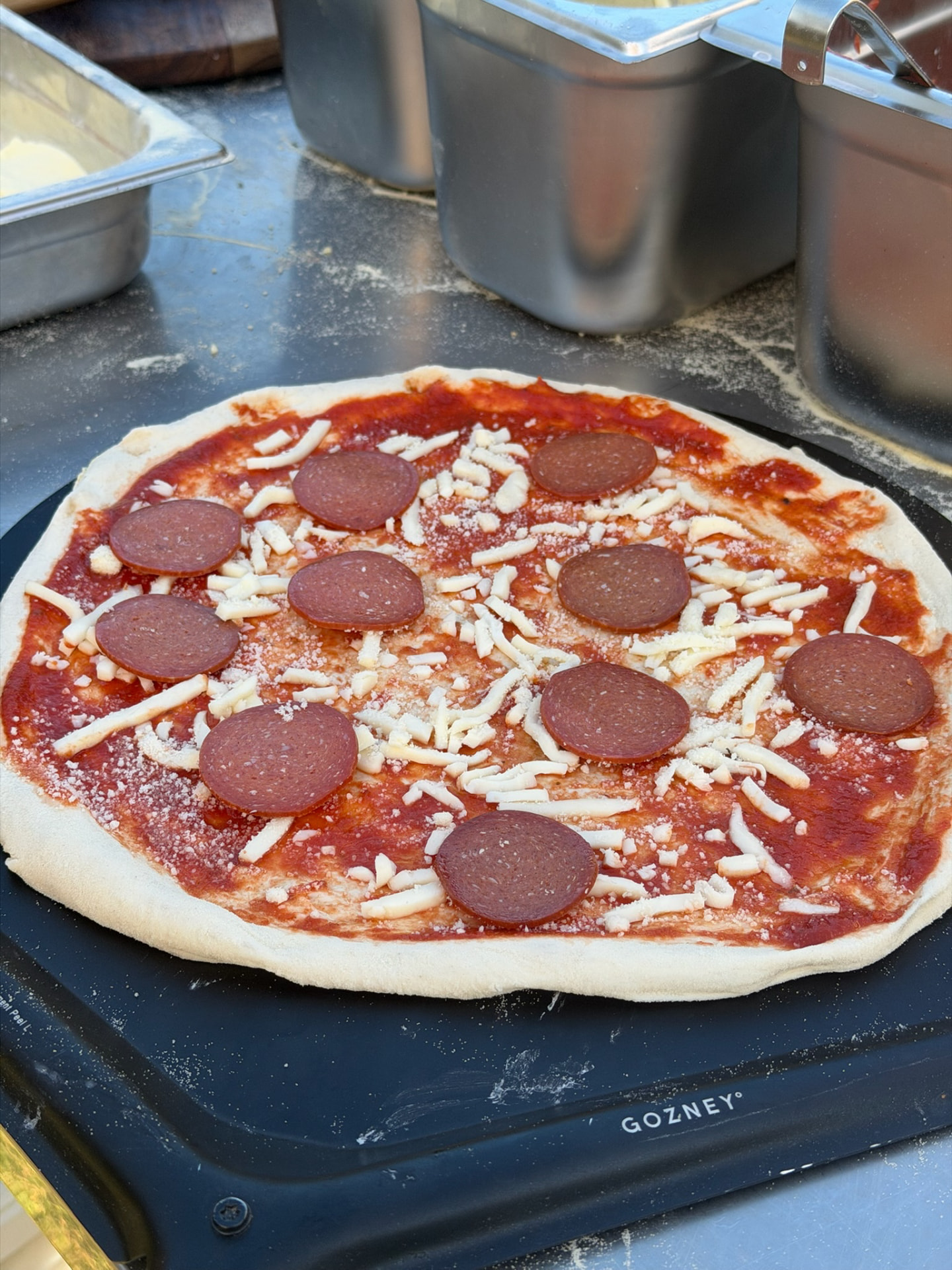 Salamipizza wordt voorbereid voor de oven