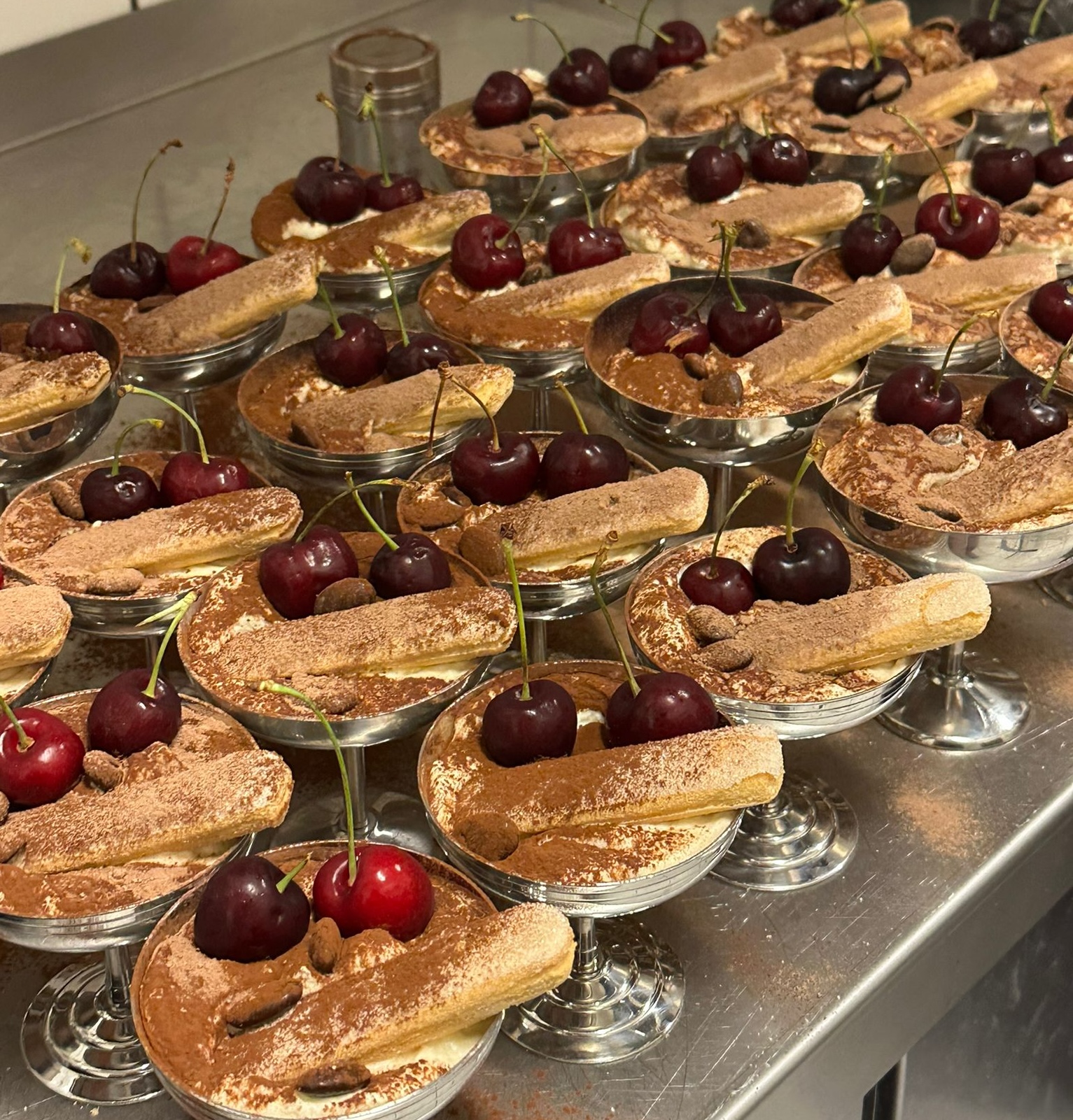 Tiramisu met verse kersen op zilveren coupes