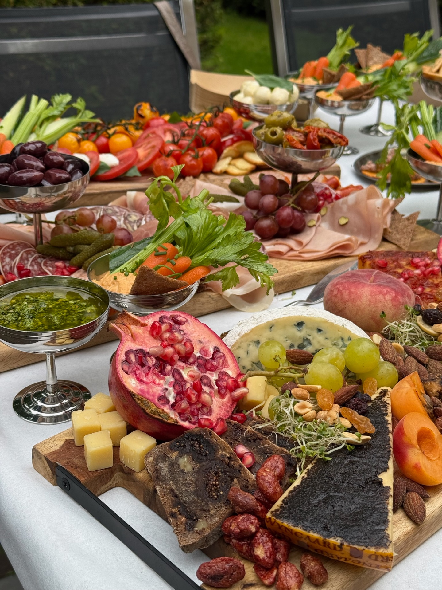 Grazing tafel met kaas, fruit en charcuterie in de tuin