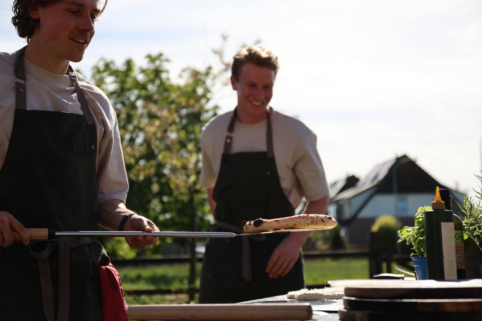 Joep en Renz aan het werk bij de pizzaoven